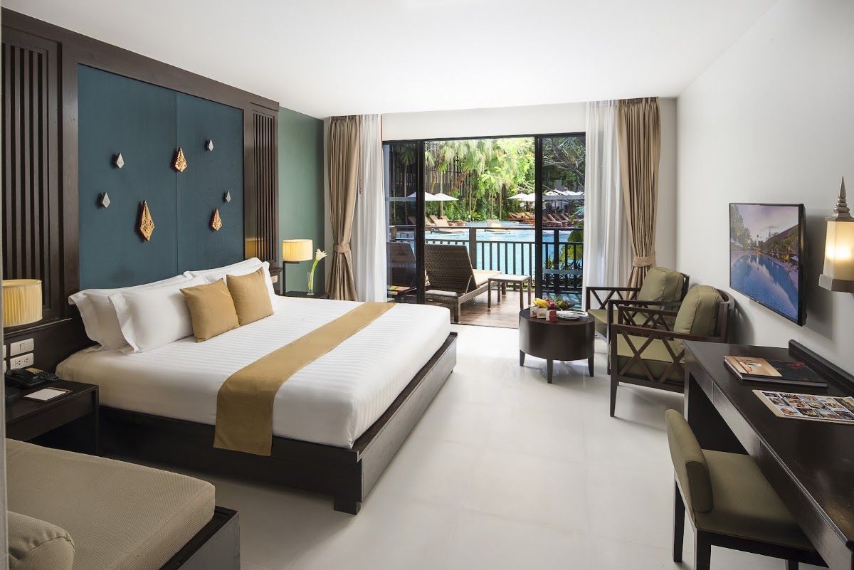 A pool-access room at Centara Anda Dhevi Resort & Spa Krabi, balcony overlooking the pool deck and tropical garden