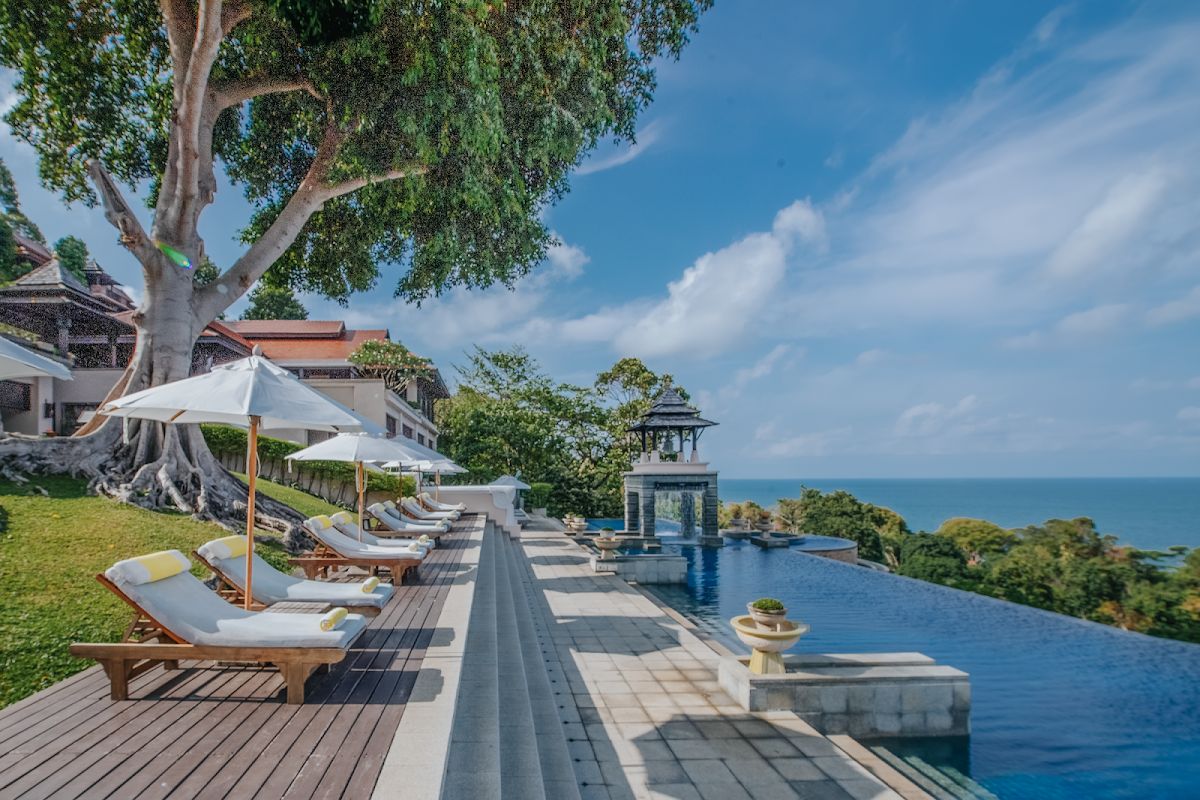 Infinity pool and sun loungers at a luxury resort in Krabi with tropical gardens and sea views